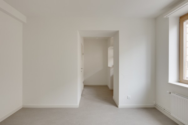Slaapkamer met witte muren en veel lichtinval in de Fierensblokken. © Bart Gosselin