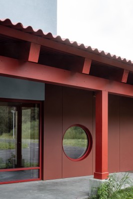 Detail van de rode luifel met rond raam.