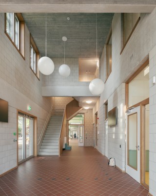 Hoge en ruime hal met lampen in de vorm van witte bollen.
