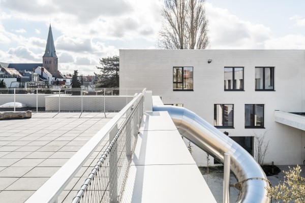 Glijbaan vanop de speelplaats op het dak naar de onderste speelplaats