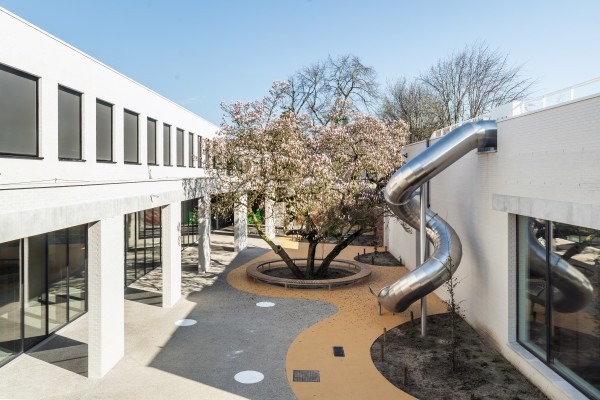 Speelplaats met magnolia en glijbaan