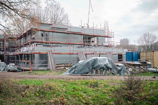 bouwwerf met halfafgewerkt gebouw achter stellingen