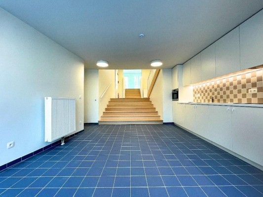 gemeenschappelijke grote keuken met witte meubels en blauwe vloertegels