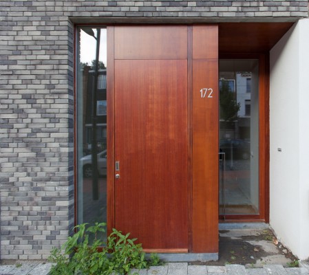 Dubbele voordeur opgetrokken uit hout en glas wat zorgt voor veel natuurlijk lichtinval.