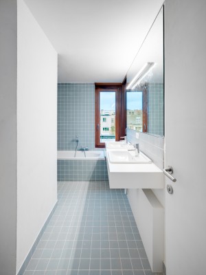 De badkamer is volledig voorzien van blauwe tegel, een dubbele wastafel, ligbad en inloopdouche. 