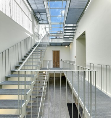 Inkom met ijzeren trappencomplex dat toegang geeft tot het kantoorgedeelte.