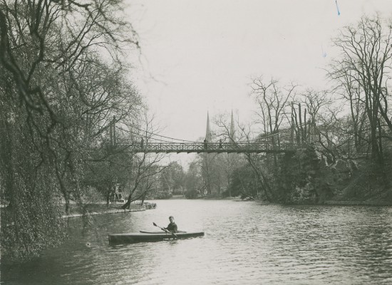 Zwartwit foto waarop een volle stadsvijver met een roeier op te zien is. Op de achtergrond staat de Keiligbrug.