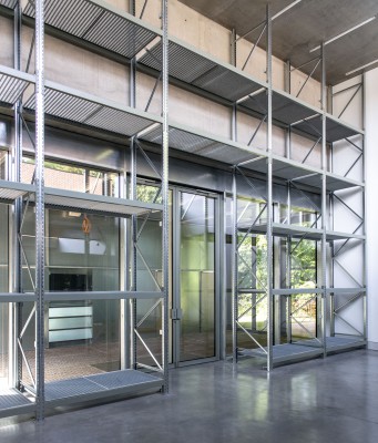 Aan de binnenzijde van de tentoonstellingsruimte zijn metalen rekken met 5 verdiepingen aan de wand geplaatst. In het midden is er een opening voor de inkomdeur.