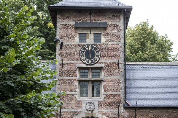 In de toren van het poortgebouw is een uurwerk met Romeinse cijfers te zien.