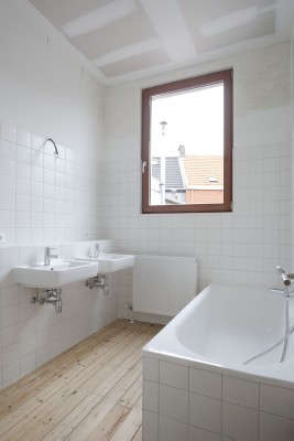 De wit betegelde badkamer is voorzien van ligbad en lavabo.