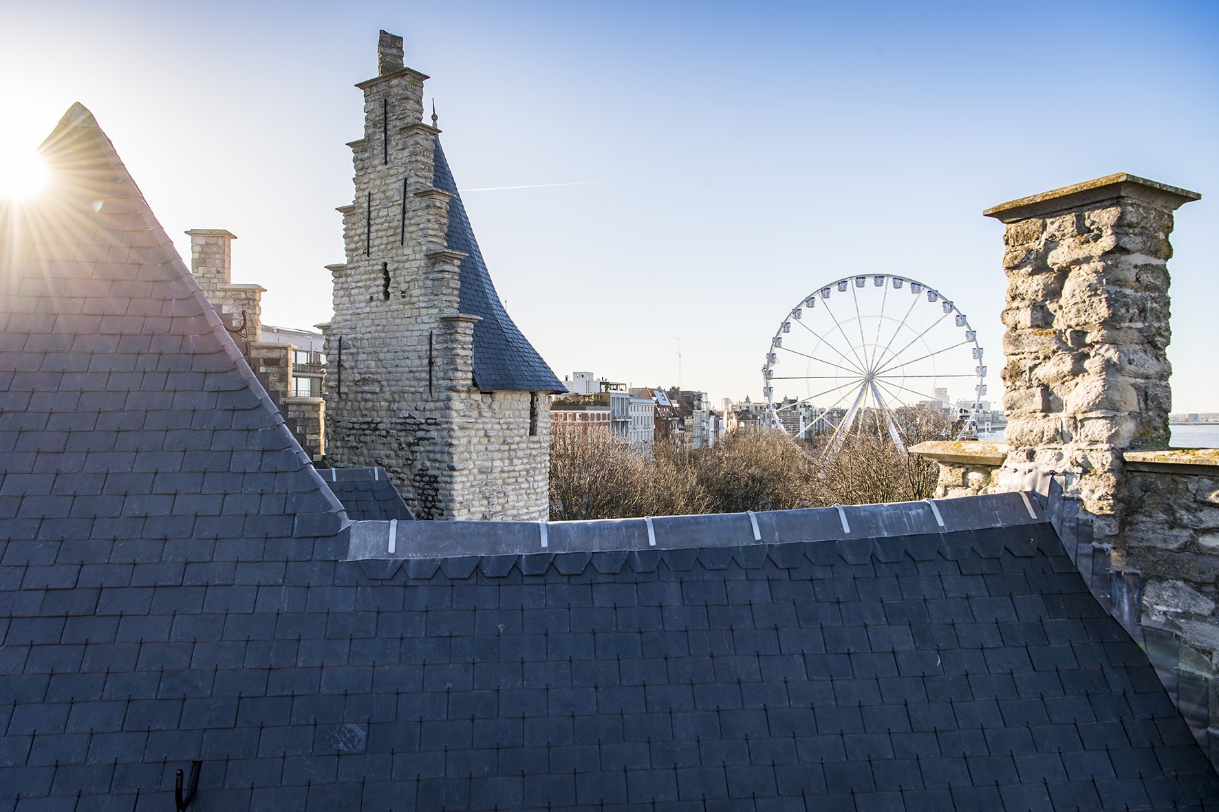 Het gerenoveerde dak van Het Steen met zicht op een reuzenrad aan de Scheldekaaien.