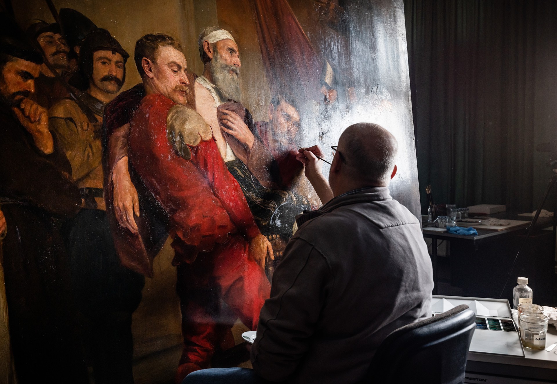 restaurator Marc Leenaerts restaureert een schilderij van Emile Godding uit het stadhuis van Antwerpen.