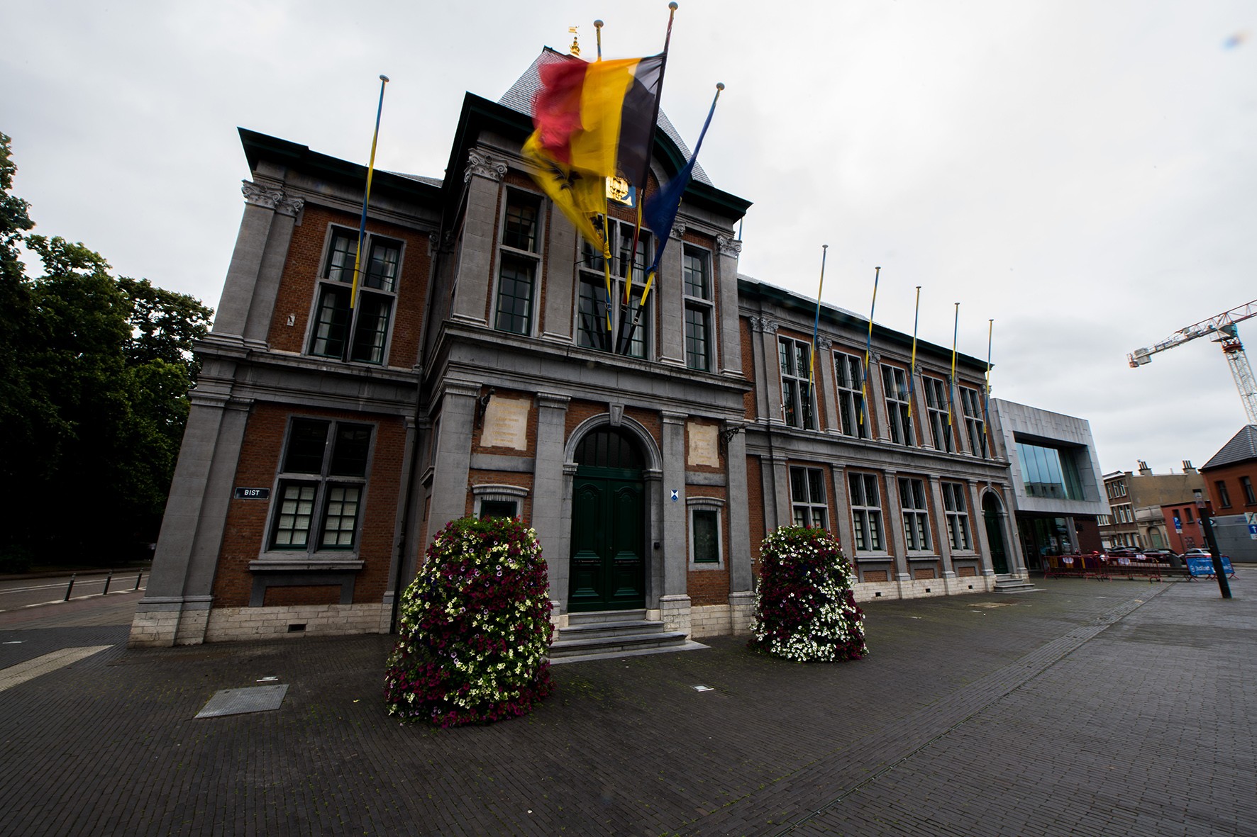 Voorgevel van het districtshuis met wapperende vlaggen
