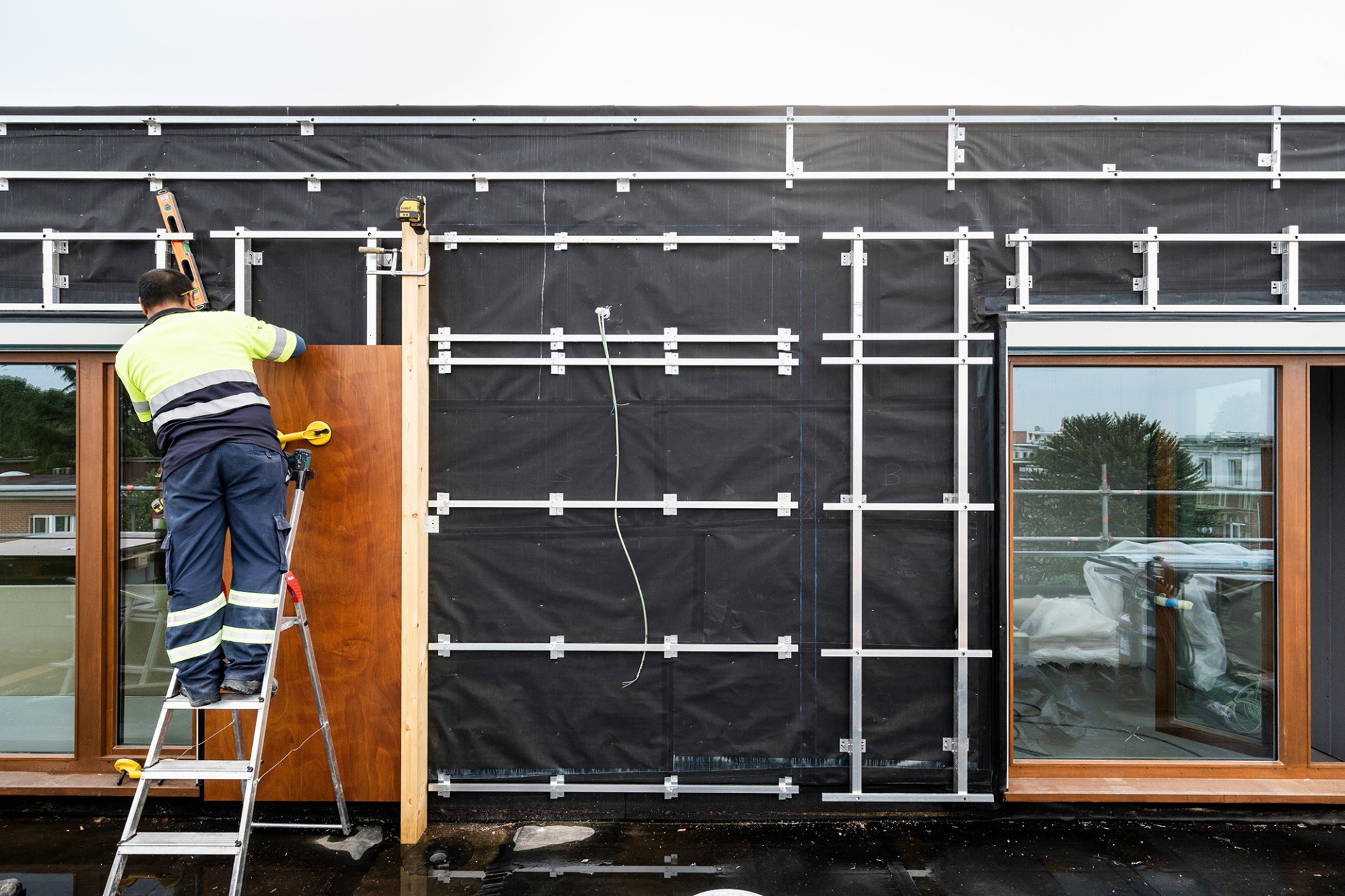 Een vakman werkt aan de gevel van het gebouw.