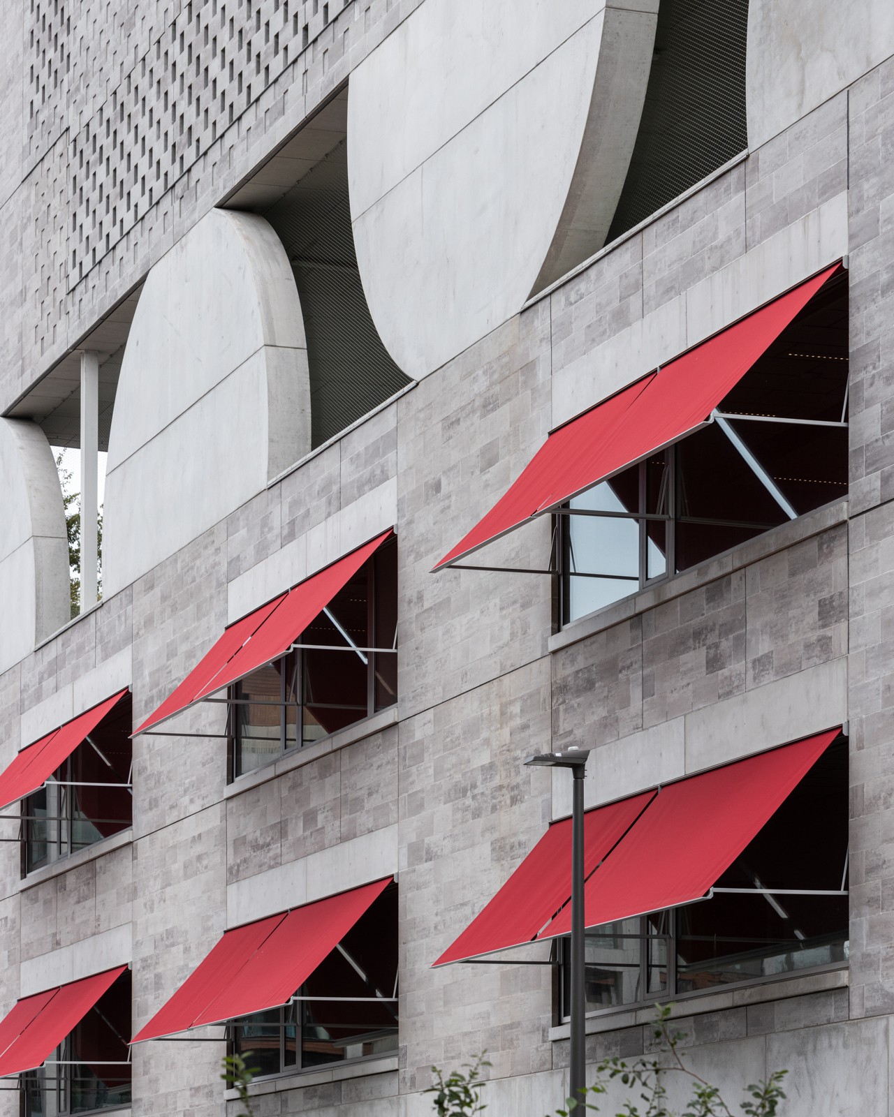 Gevel schoolgebouw met rode luifels