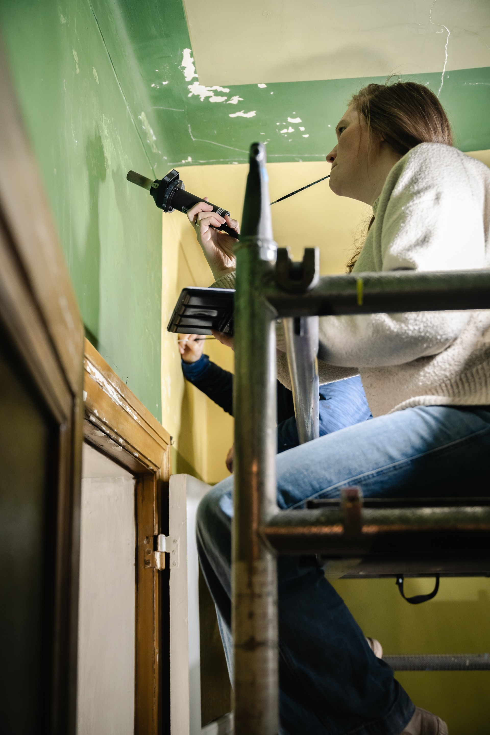 Restauratrice werkt aan de beschadigde muurschildering