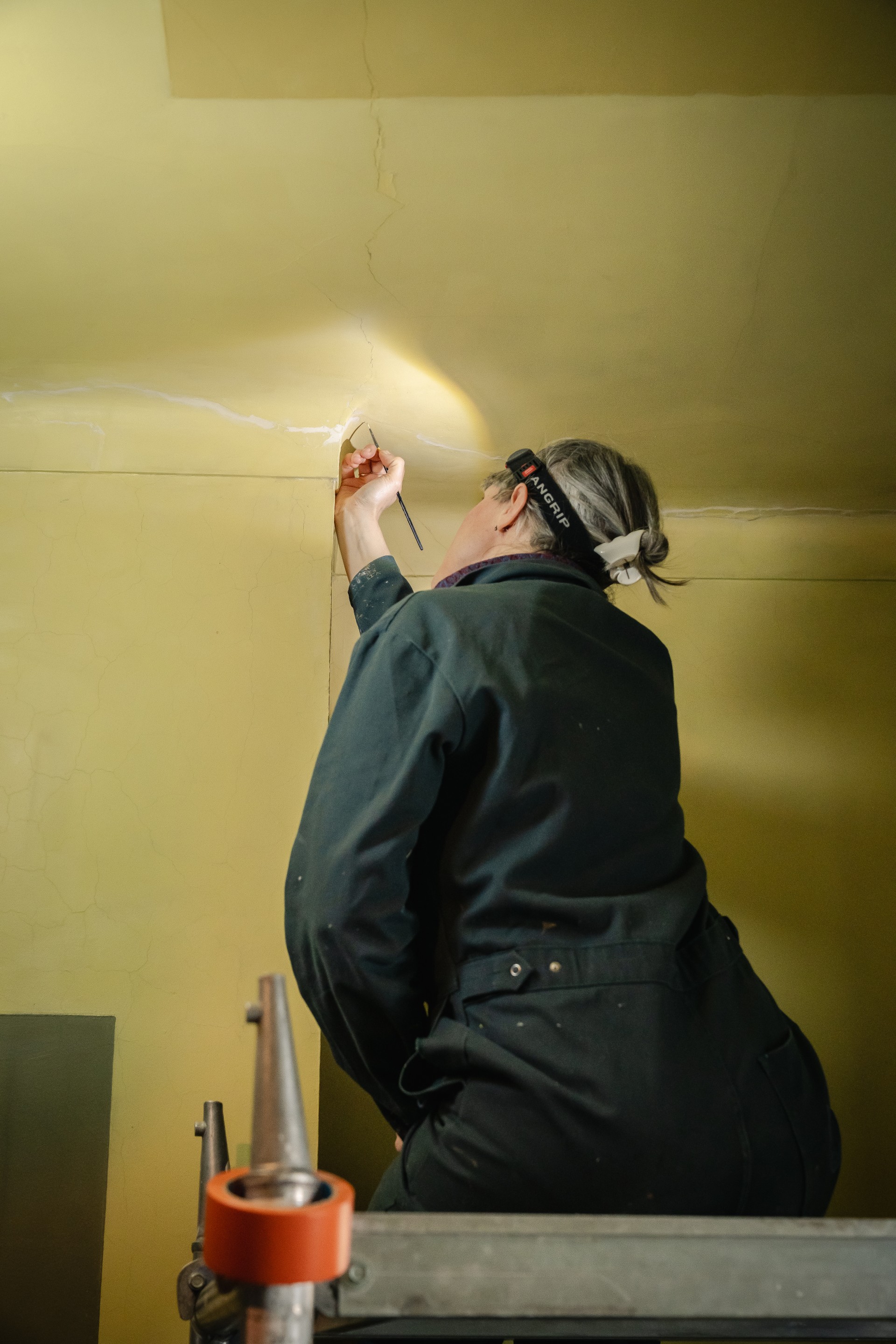 restauratrice werkt aan het plafond
