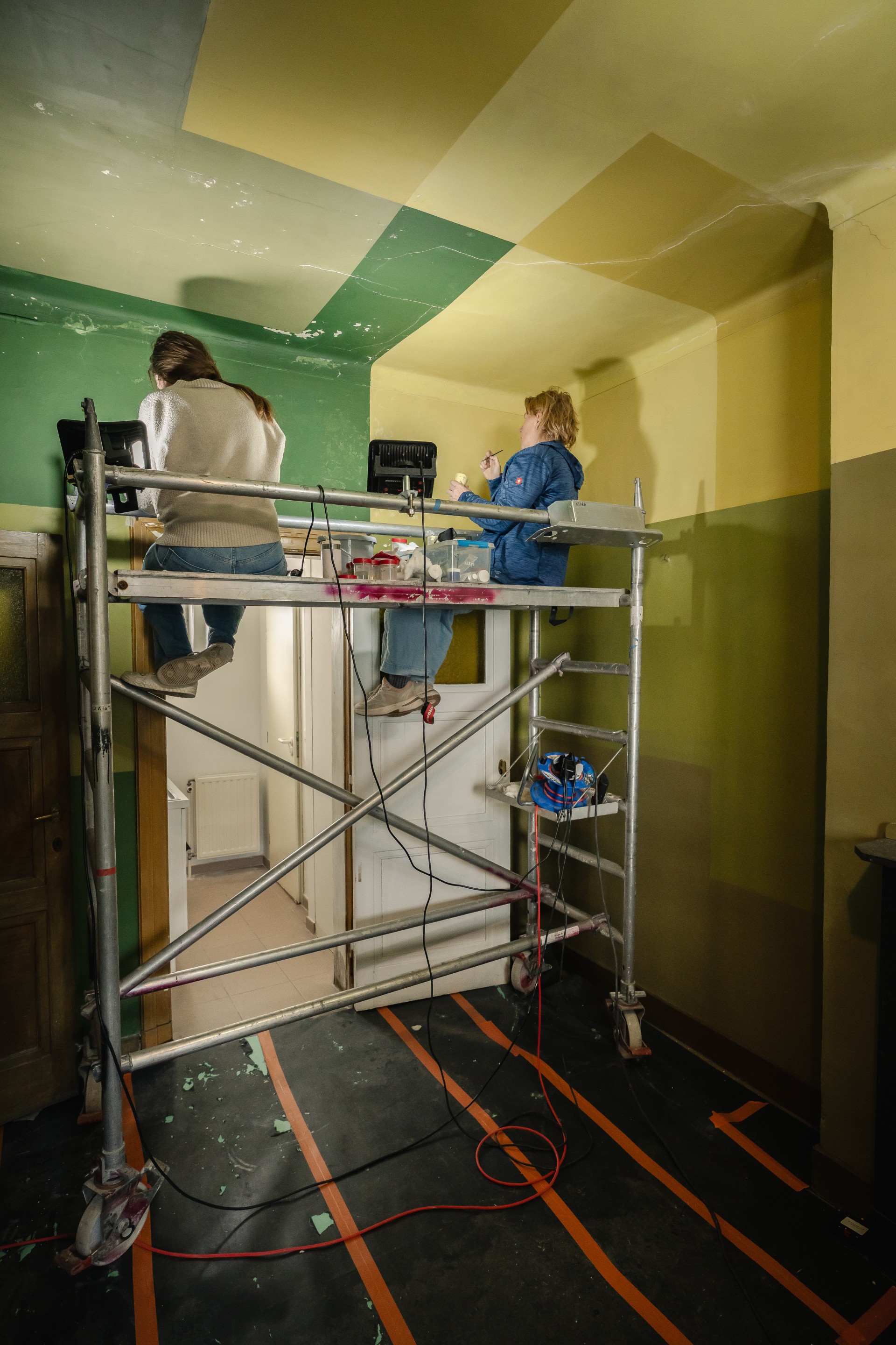 Twee restauratrices op stellingen aan het werk