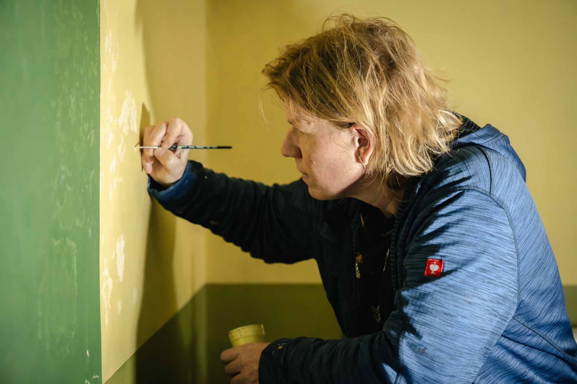 Restauratrice aan het werk aan muur