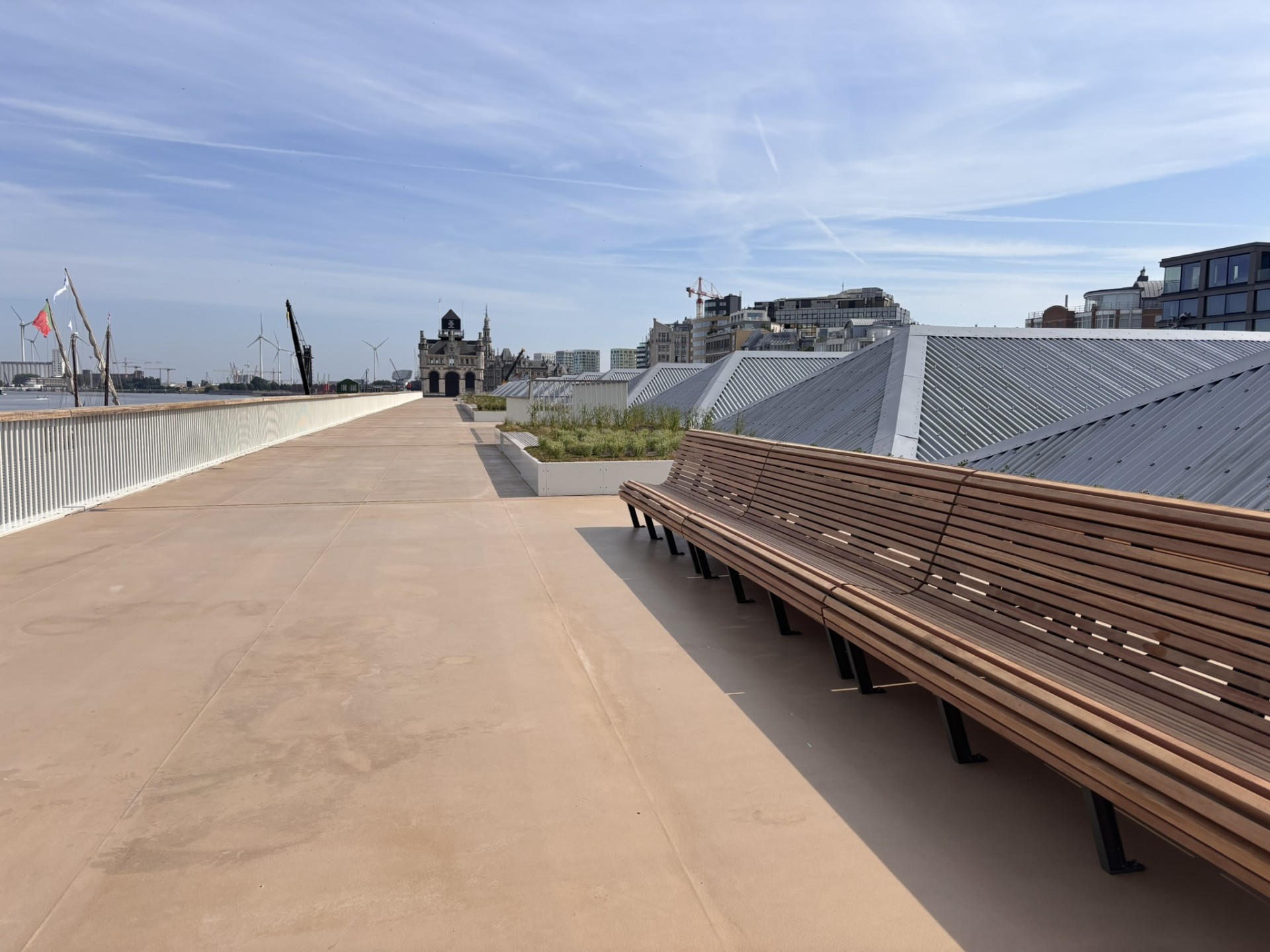 Lange zitbank met erachter een bloembak op het verhoogd wandelterras