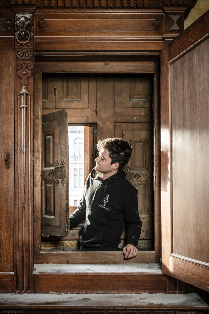 Martijn Remmen bekijkt het geopende 16e-eeuwse raam dat verstopt achter een houten wandkast.