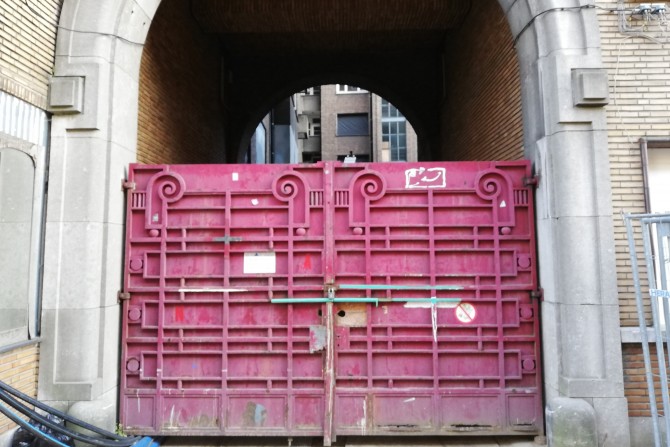 De bordeauxrode poort van de Fierensblokken voor renovatie. 