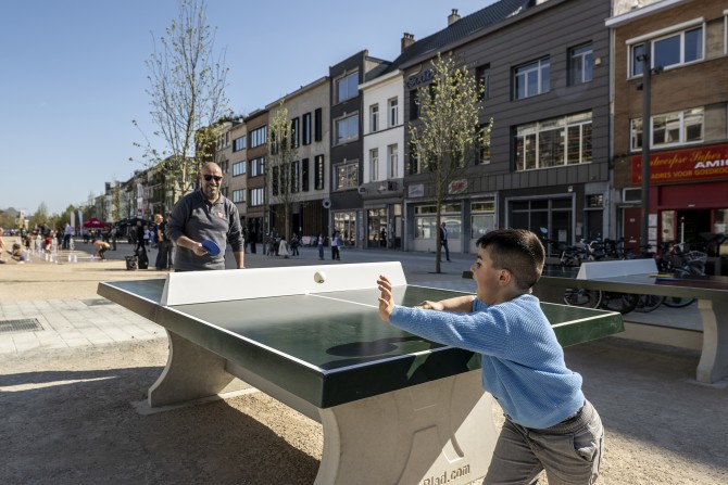 Kind en volwassene spelen tafeltennis op een buitentafel aan het Vetten Osplein