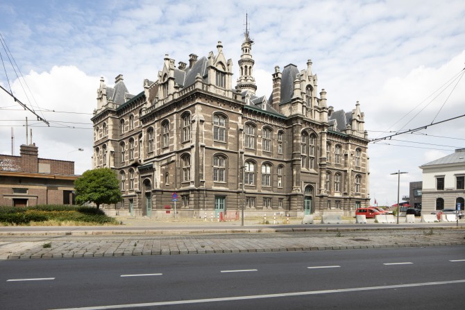 Monumentaal gebouw met sierlijk torentje achter een rijbaan