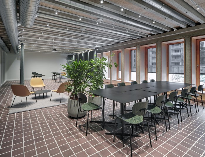 Kantoorruimte met verschillende opstellingen van tafels en stoelen voor grote en kleine groepen.