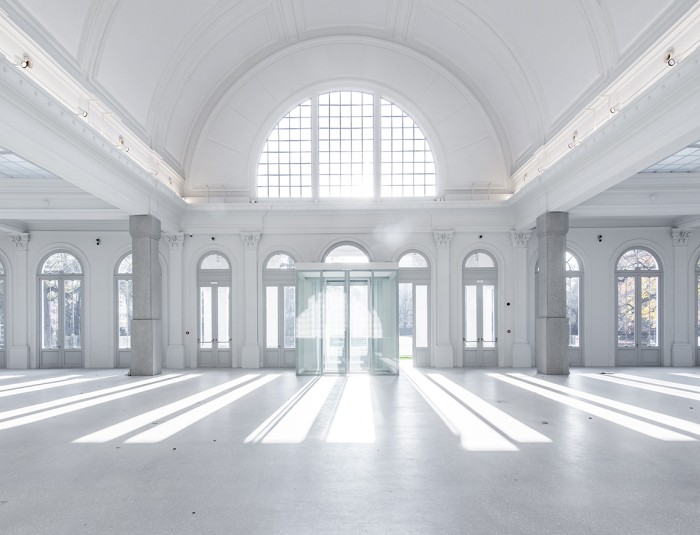 De zaal heeft grote boogramen, een terrazzovloer en zuilen bekleed met terrazzoplaten.