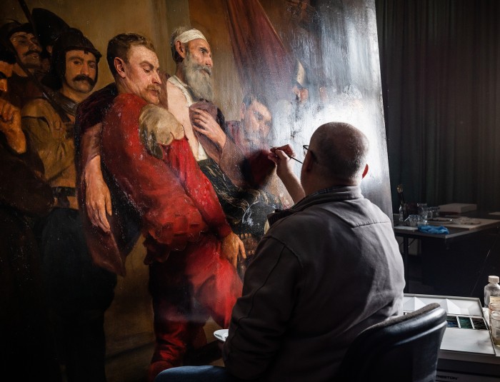 restaurator Marc Leenaerts restaureert een schilderij van Emile Godding uit het stadhuis van Antwerpen.