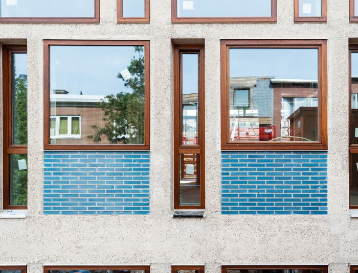 Voorgevel met blauwe geglazuurde stenen en houten schrijnwerk