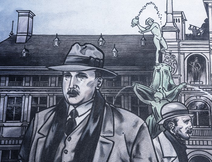 detail uit de muurschildering met man op voorgrond en stadhuis op achtergrond