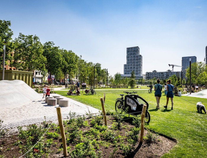 Zicht op het Zuidpark met speeltuin, gras en bomen.