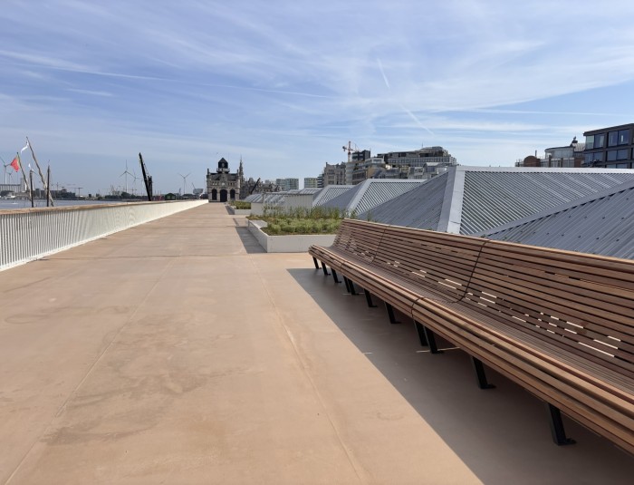 Lange zitbank met erachter een bloembak op het verhoogd wandelterras