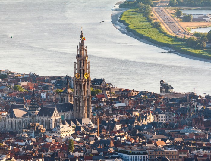 Luchtfoto waarop scheldebocht, de historische stad met kathedraaltoren te zien is.